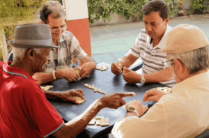 A group of senior adults playing dominoes.