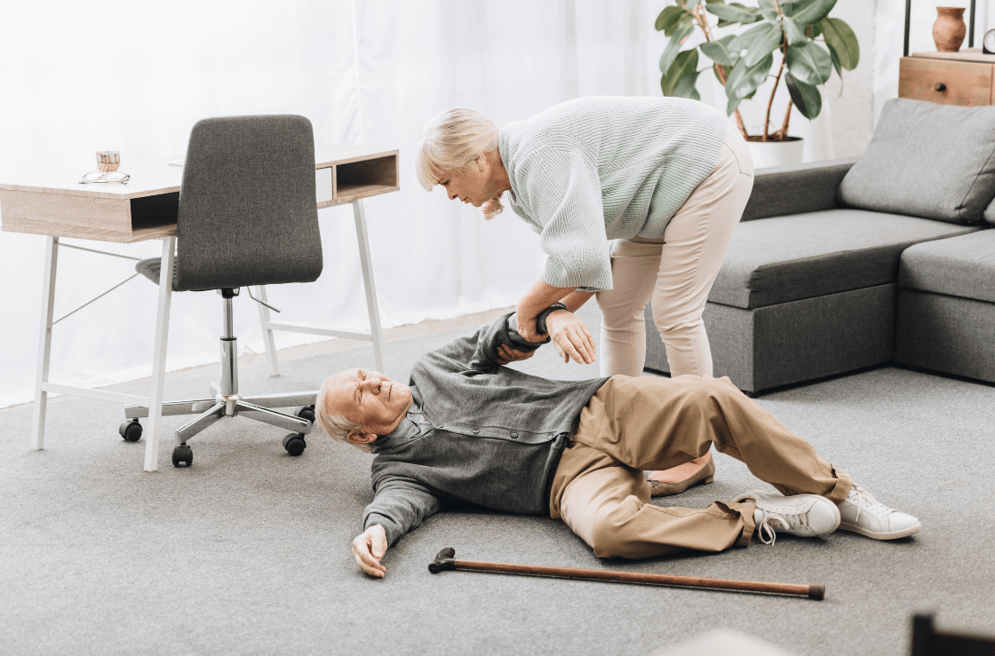 A woman assists a man who has fallen