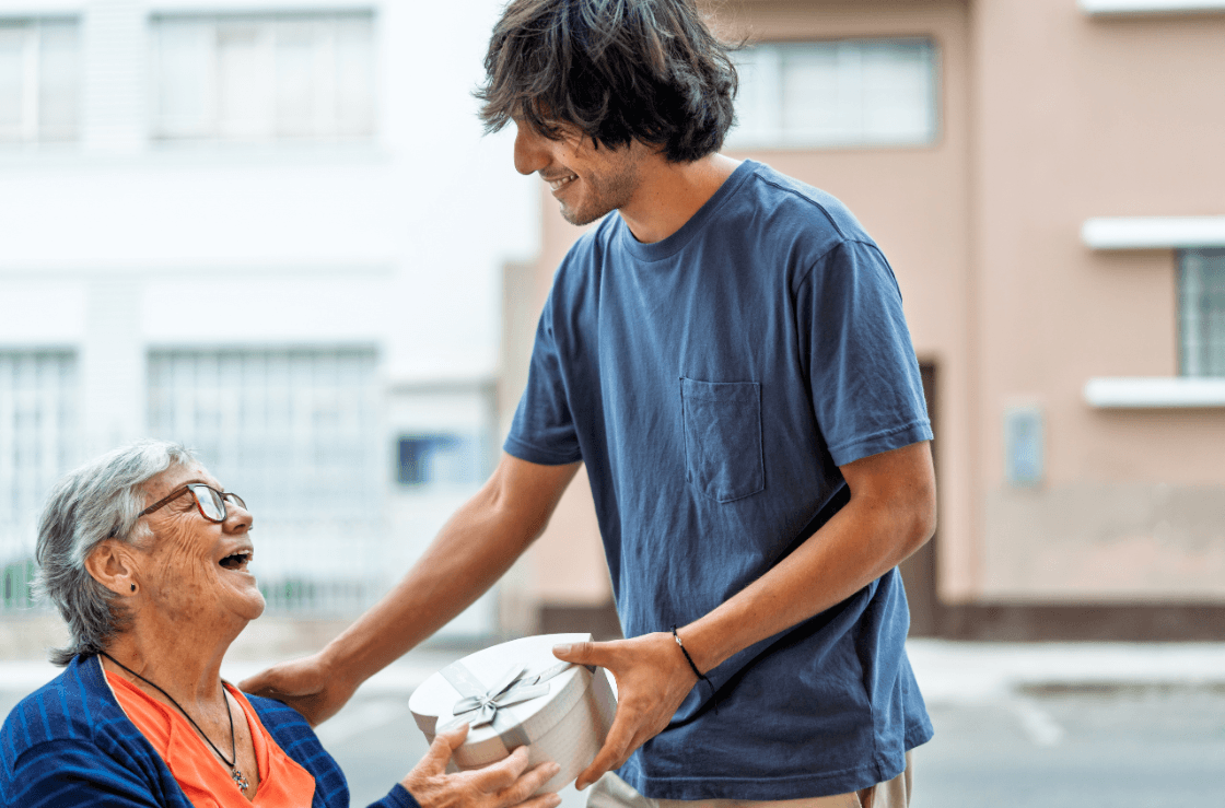 Man giving gift to woman in wheelchair