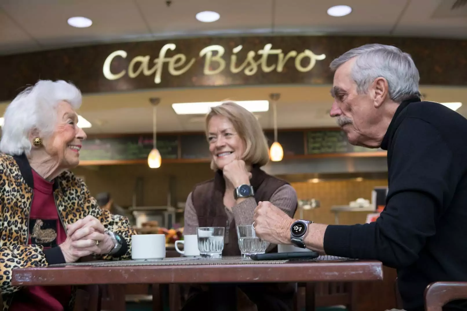 Group sitting in cafe, man wearing kanega watch