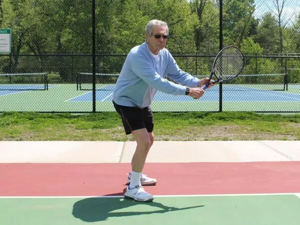 Elderly man playing tennis wearing the Kenga Watch