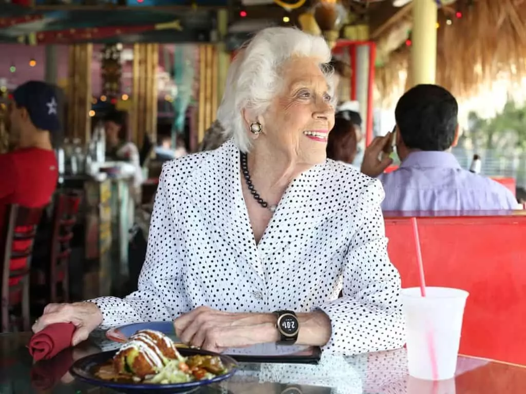 Woman sits in restaurant wearing a Kenaga Watch