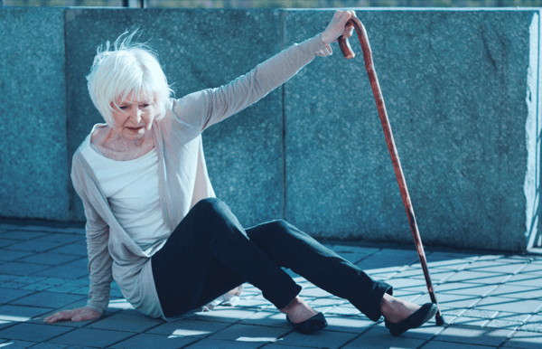 Woman sitting on the ground with a cane
